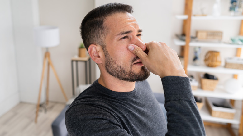 man holding his nose