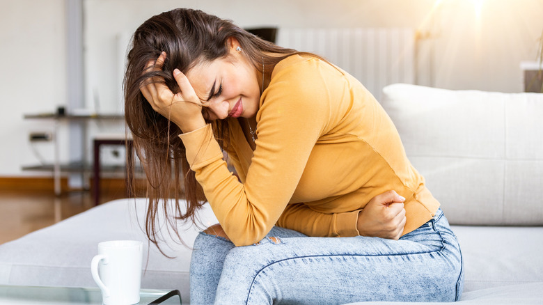 Woman grabbing her abdomen