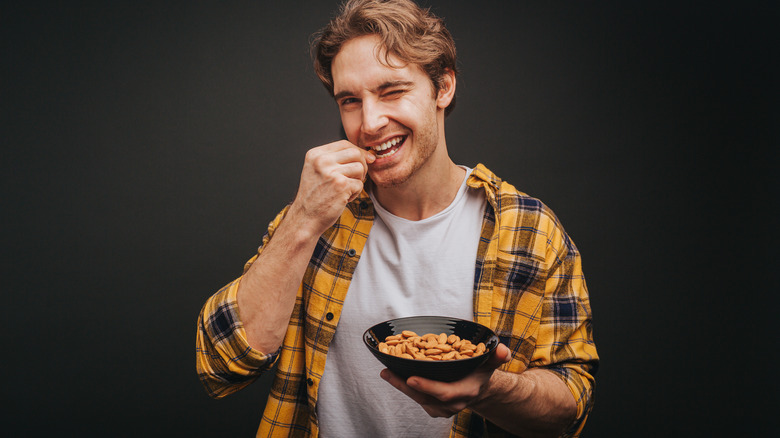 smiling man eating almonds