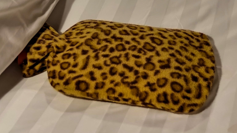 a leopard printed heating pad on a made bed 