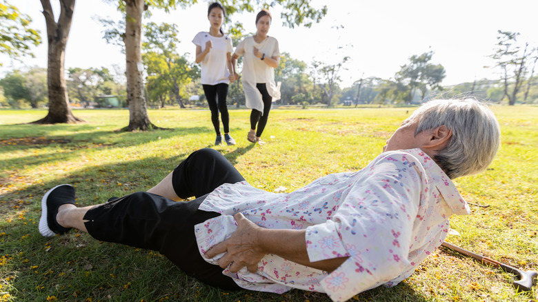 Older woman on ground holding hip