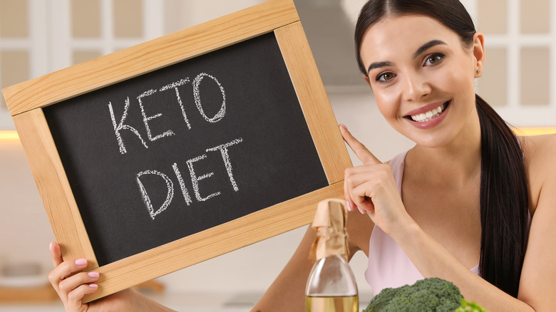 smiling woman holding keto diet sign
