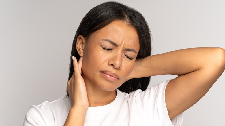 woman in pain holding neck