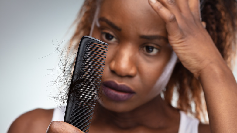 woman looking at hair in comb