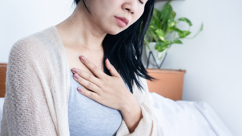 Woman holding hand to chest