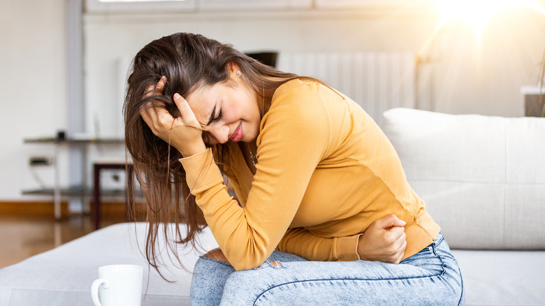 Woman holding stomach in pain