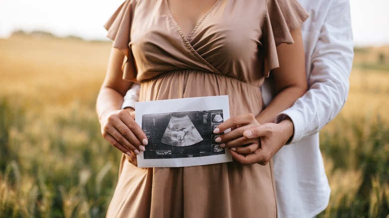 Pregnant woman holding ultrasound