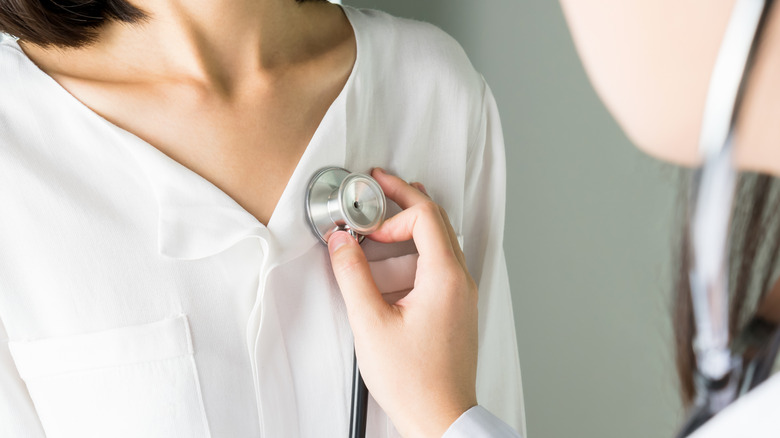 A doctor uses a stethoscope on a patient