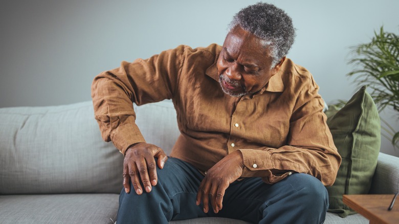 Man holding knee in pain