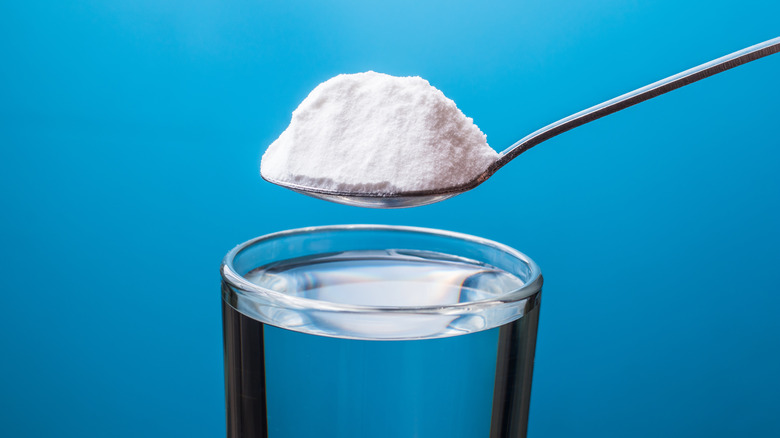 spoon of baking soda over a glass of water