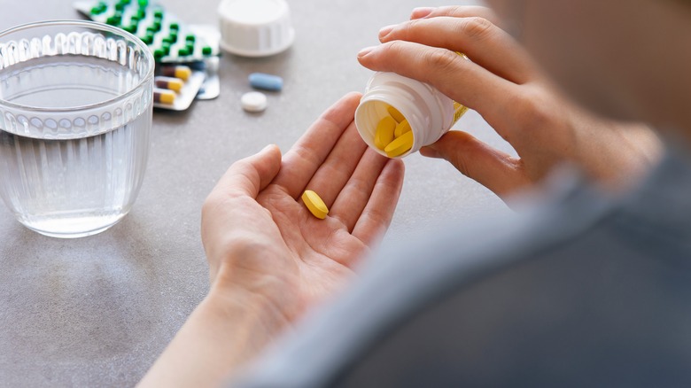 woman holding a pill in hand