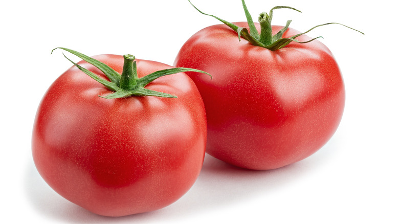 Two round tomatoes on white background