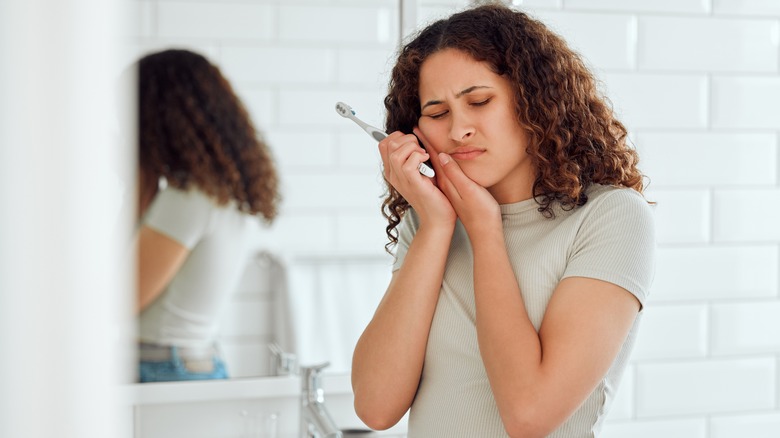 woman holding face in pain