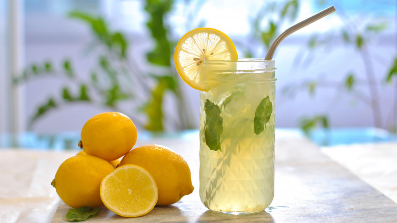 A glass of water with lemon and herbs 