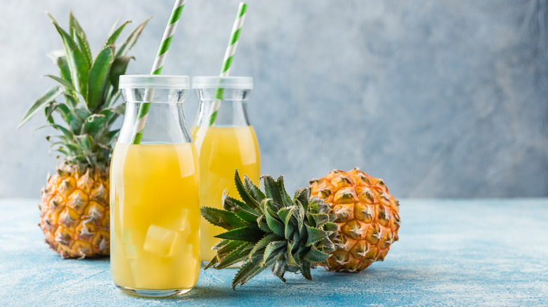 Glasses of pineapple juice with pineapples