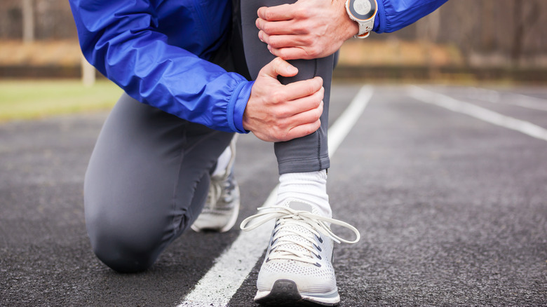 Man holding his shins in pain