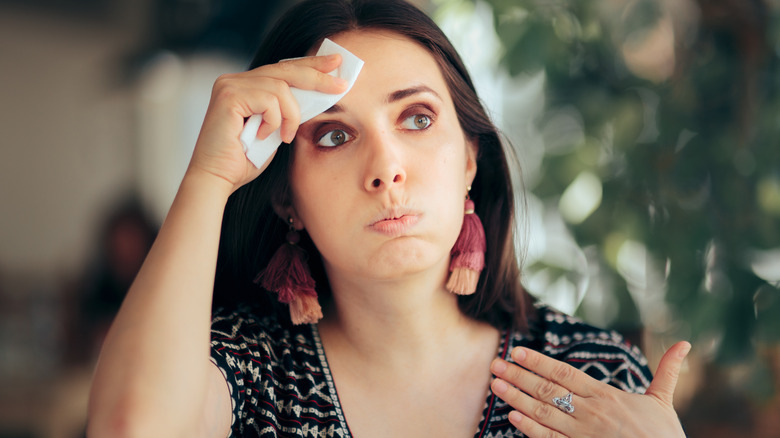 sweating woman wiping head