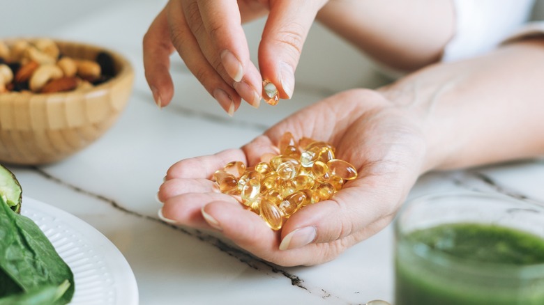 woman with many omega 3 capsules in hand