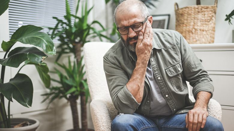 man applying pressure to his ear