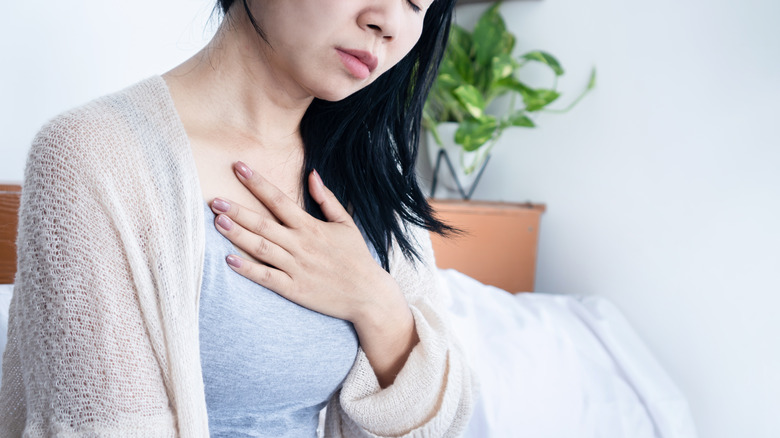 A woman pressing a hand to her chest