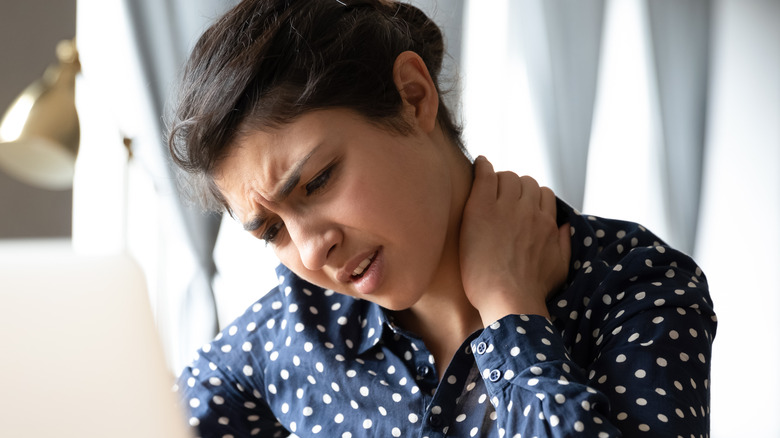 A woman holding her neck