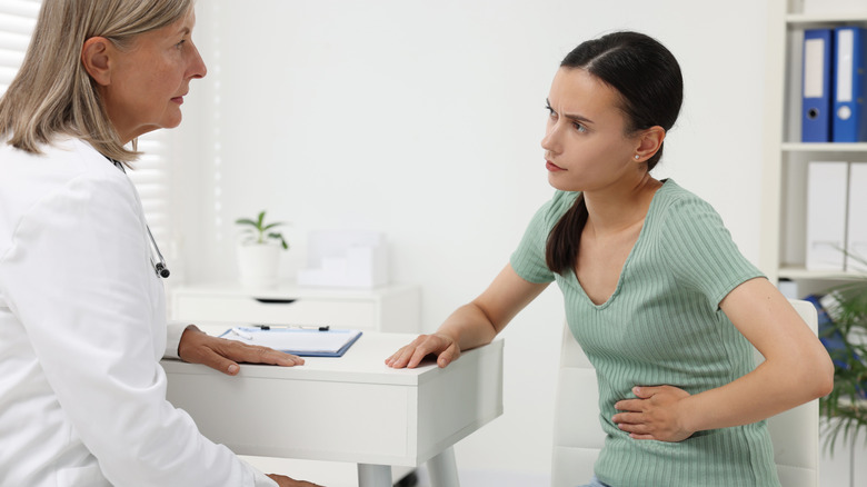 woman with stomach discomfort with doctor at visit