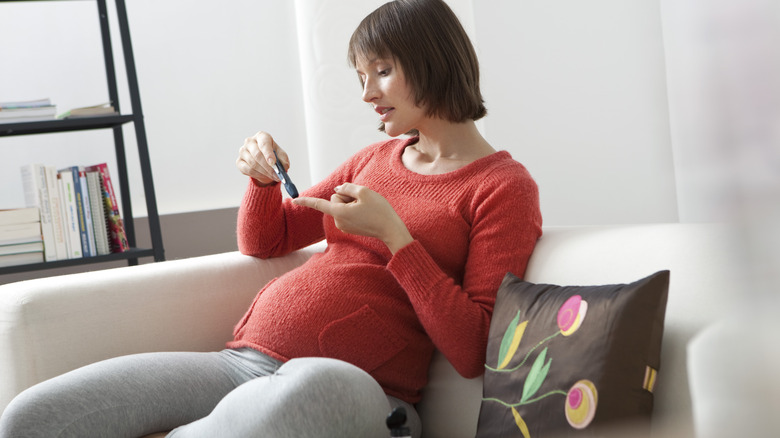 pregnant woman measuring blood sugar