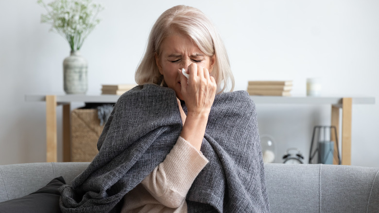 older woman wiping her nose