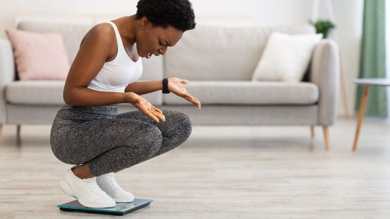 woman disappointed by weight scale