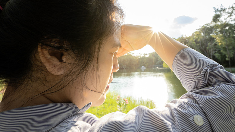 woman blocking excessive light with her hand
