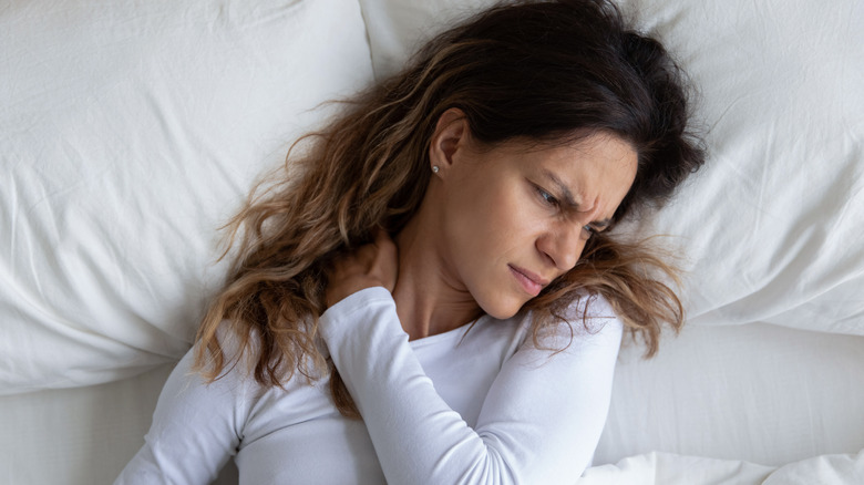 Woman in bed with crick in neck
