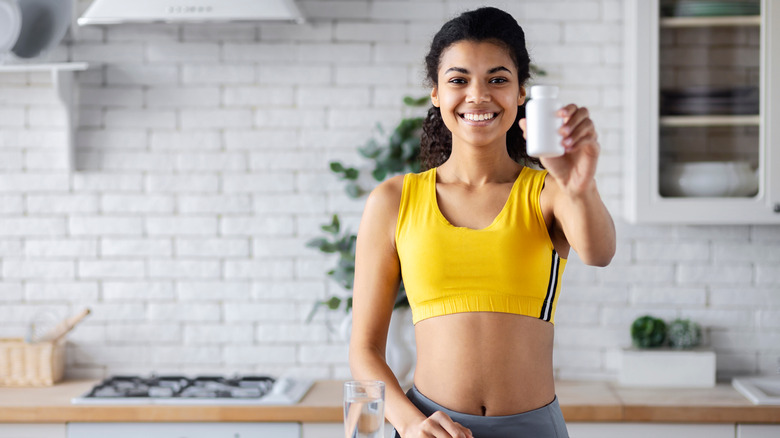 woman holding pill bottle in the kitchen