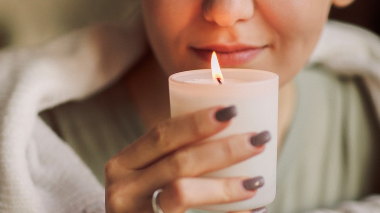 Woman smelling scented candle