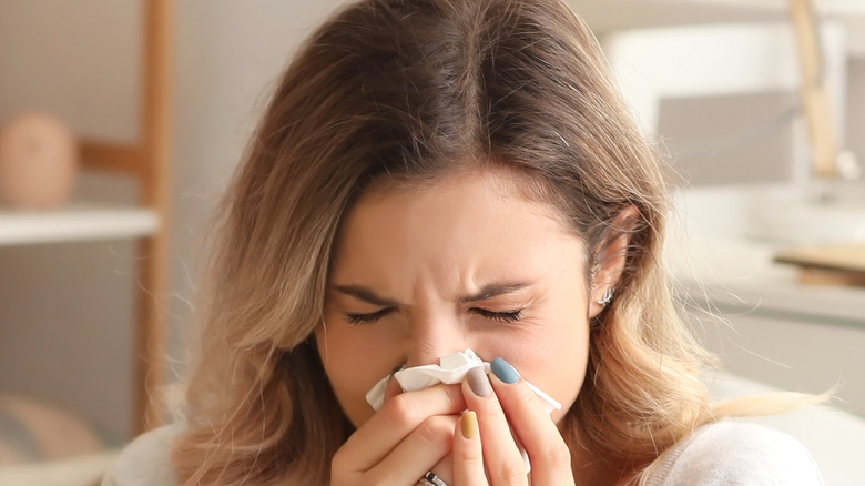 Woman blowing her nose