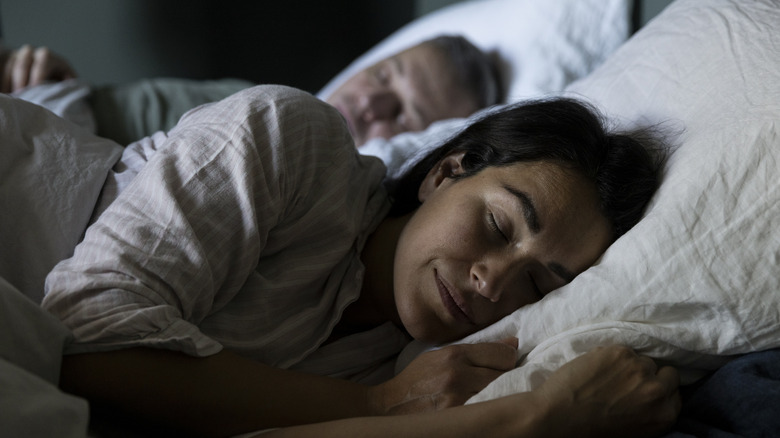 A woman and man lying in bed asleep