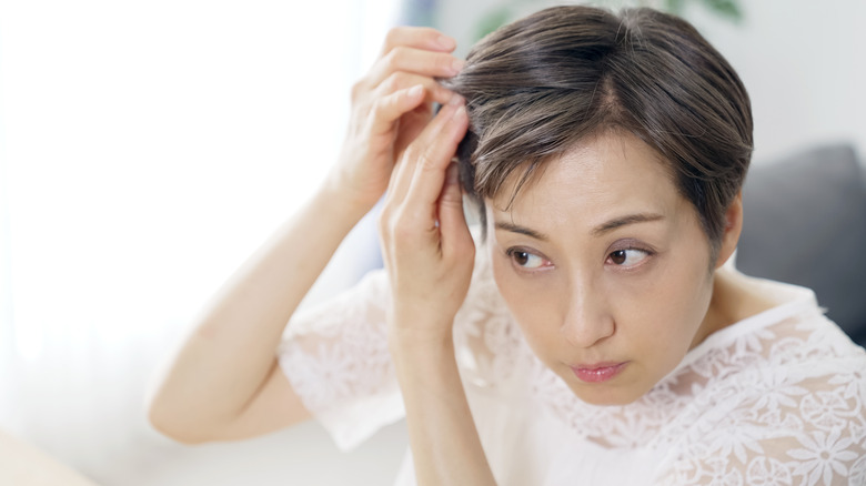 Woman examining her hair