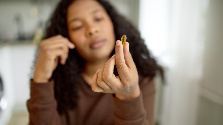 person holding fish oil supplements