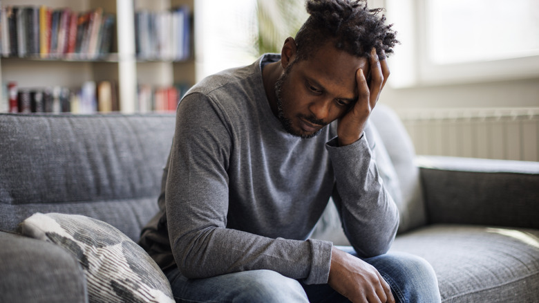 Depressed man with head in hand