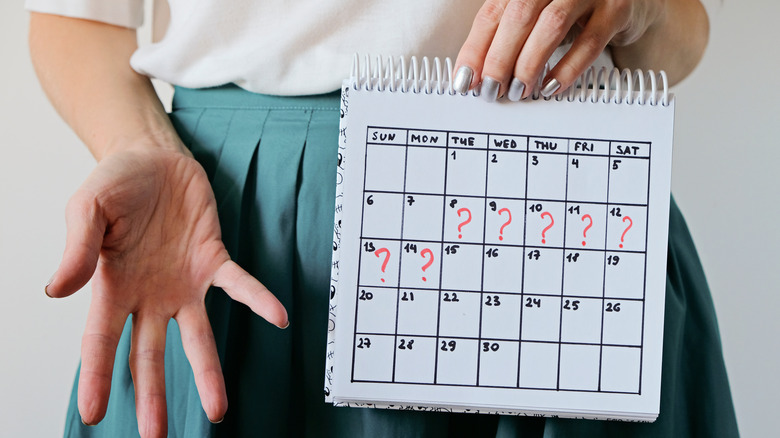 woman holding missed period calendar