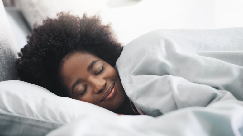 Woman happily sleeping in bed