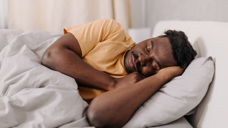 man sleeping peacefully on sofa bed