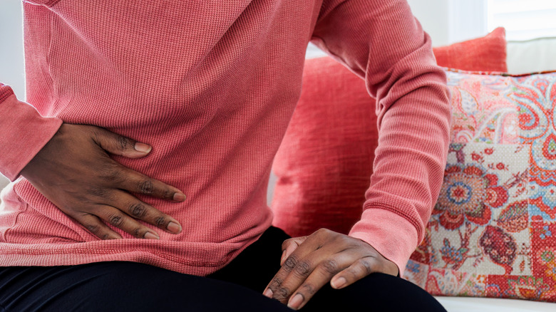woman grabbing stomach in discomfort