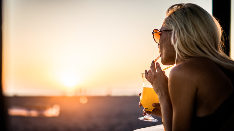 Girl drinking mocktail watching sunset