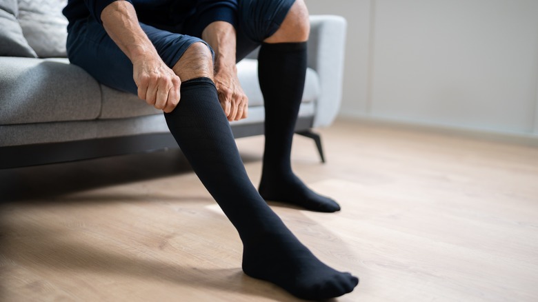 man puling up compression socks