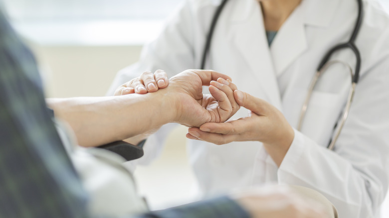 Doctor examining patient's hand