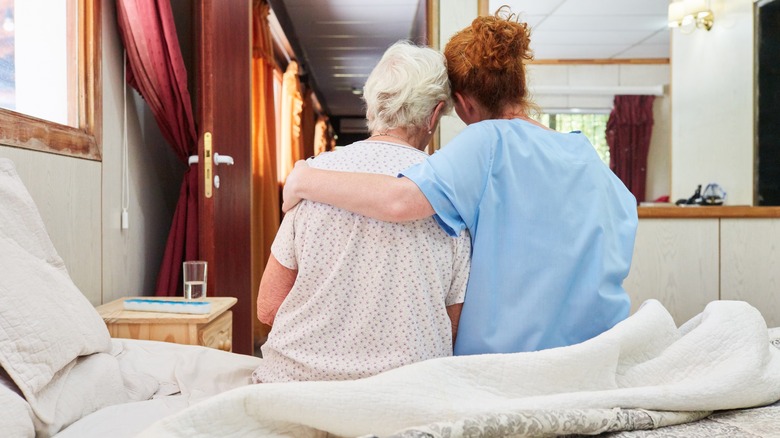 Old lady being hugged nurse