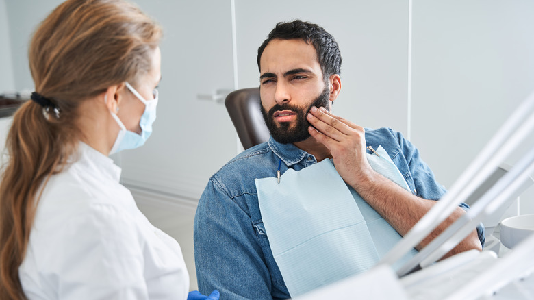 man sitting in the dentist's chair with a toothache 