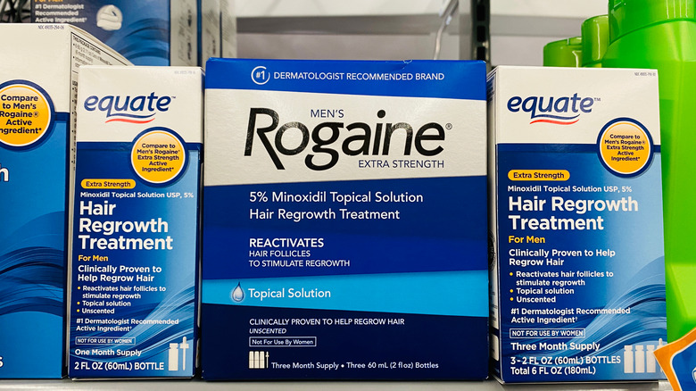 Box of Men's Rogaine Extra Strength on shelf alongside other hair growth treatment products