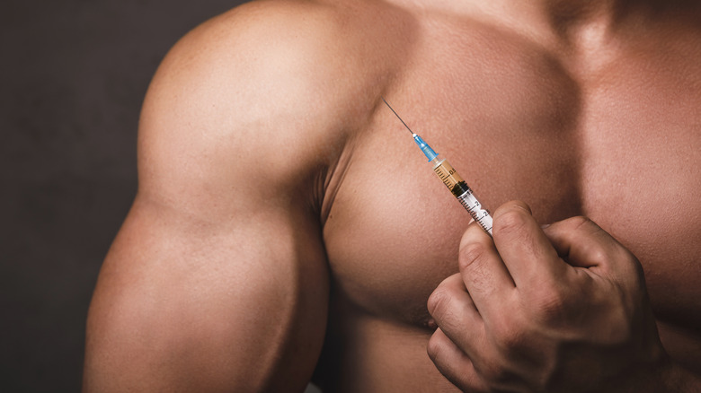 Muscular man with syringe