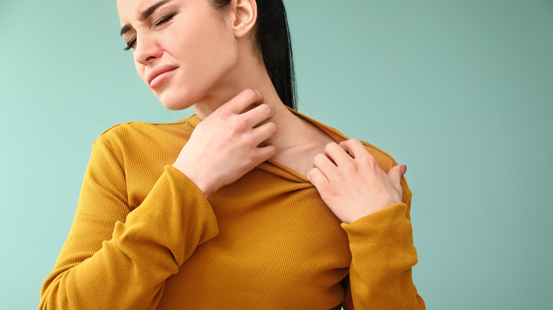 a woman scratching from allergies 